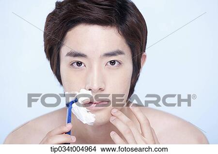 Picture - a topless man starting to shave. Fotosearch
