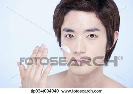 Stock Image - a topless man with a white cream lotion on his face. Fotosearch