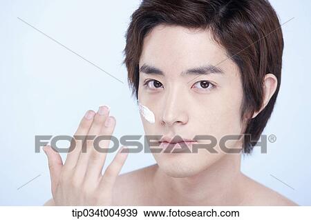 Stock Photo - a topless man with a white cream lotion on his face. Fotosearch