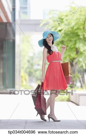A woman in dress posing with many shopping bags View Large Photo Image Stock Photograph - A woman in dress posing with many shopping bags. Fotosearch