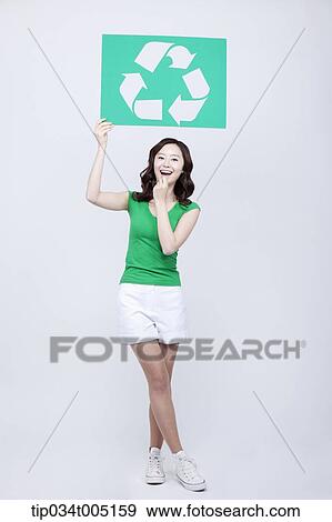 a woman in green t-shirt posing with a recycling logo signboard View Large Photo Image Stock Photo - a woman in green t-shirt posing with a recycling logo signboard . Fotosearch