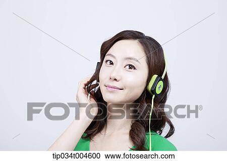 Stock Image - A woman in green T-shirt wearing a green headset. Fotosearch