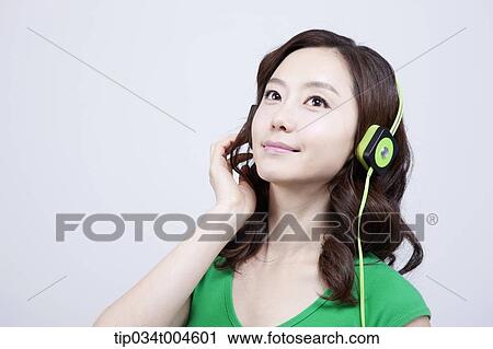 Stock Image - A woman in green T-shirt wearing a green headset. Fotosearch