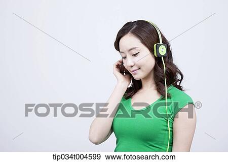 Stock Photo - A woman in green T-shirt wearing a green headset. Fotosearch