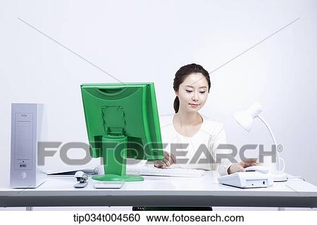 a woman sitting at office desk working View Large Photo Image Stock Image - a woman sitting at office desk working . Fotosearch