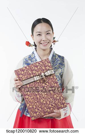 a woman wearing a Hanbok holding a present View Large Photo Image Stock Image - a woman wearing a Hanbok holding a present . Fotosearch