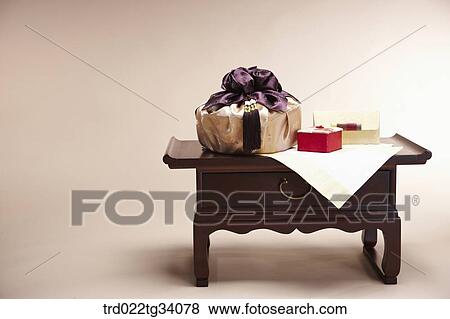 Stock Photo - an envelope and packages in Korean traditional wraps placed on a traditional table . Fotosearch