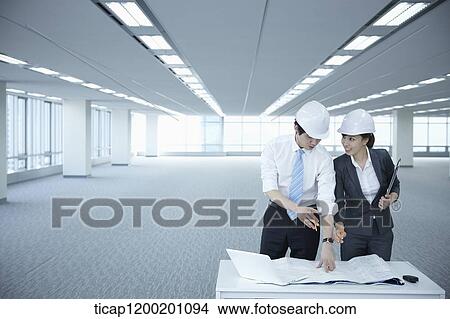 architect executives discussing with blueprints on a desk of an empty room View Large Photo Image Picture - architect executives discussing with blueprints on a desk of an empty room. Fotosearch