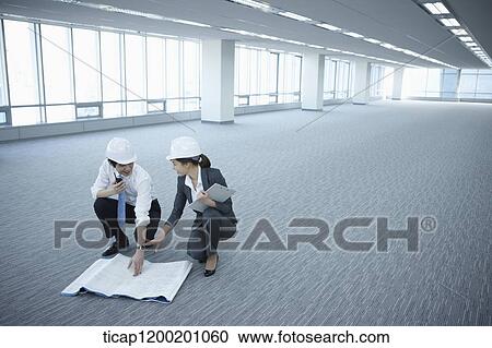 architect executives discussing with blueprints on the floor of an empty room View Large Photo Image Stock Image - architect executives discussing with blueprints on the floor of an empty room . Fotosearch