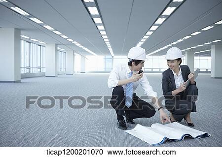 architect executives discussing with blueprints on the floor of an empty room View Large Photo Image Stock Image - architect executives discussing with blueprints on the floor of an empty room . Fotosearch