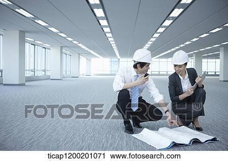 architect executives discussing with blueprints on the floor of an empty room View Large Photo Image Stock Image - architect executives discussing with blueprints on the floor of an empty room . Fotosearch