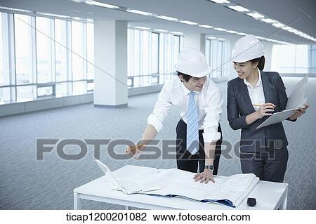 architect executives discussing with blueprints on a desk of an empty room View Large Photo Image Stock Image - architect executives discussing with blueprints on a desk of an empty room. Fotosearch