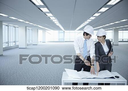 architect executives discussing with blueprints on a desk of an empty room View Large Photo Image Stock Image - architect executives discussing with blueprints on a desk of an empty room. Fotosearch