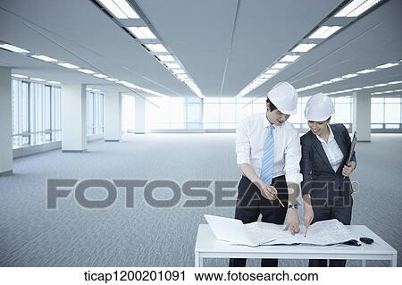 architect executives discussing with blueprints on a desk of an empty room View Large Photo Image Stock Image - architect executives discussing with blueprints on a desk of an empty room. Fotosearch