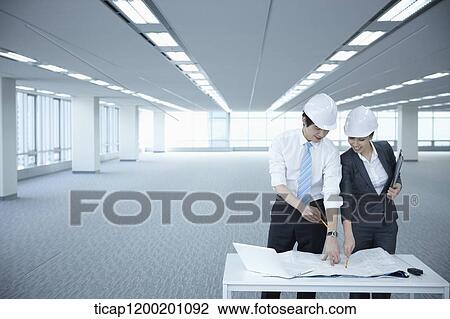 architect executives discussing with blueprints on a desk of an empty room View Large Photo Image Stock Image - architect executives discussing with blueprints on a desk of an empty room. Fotosearch