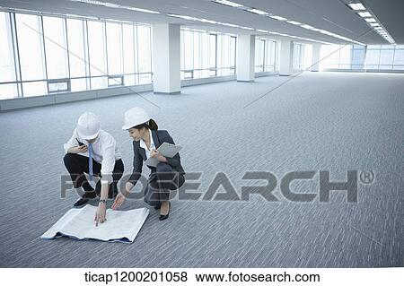 architect executives discussing with blueprints on the floor of an empty room View Large Photo Image Stock Photo - architect executives discussing with blueprints on the floor of an empty room . Fotosearch