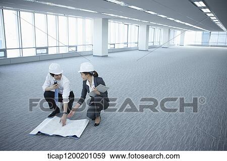 architect executives discussing with blueprints on the floor of an empty room View Large Photo Image Stock Photo - architect executives discussing with blueprints on the floor of an empty room . Fotosearch