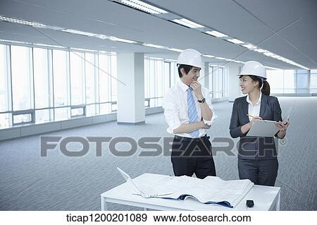 architect executives discussing with blueprints on a desk of an empty room View Large Photo Image Stock Photo - architect executives discussing with blueprints on a desk of an empty room. Fotosearch