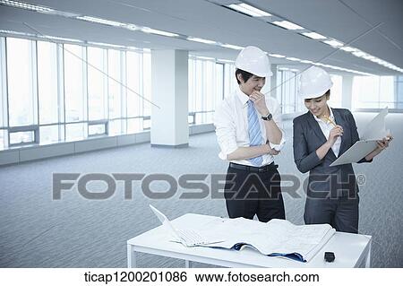 architect executives discussing with blueprints on a desk of an empty room View Large Photo Image Stock Photograph - architect executives discussing with blueprints on a desk of an empty room. Fotosearch