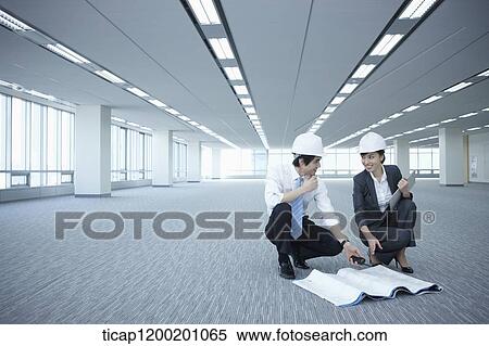 architect executives discussing with blueprints on the floor of an empty room View Large Photo Image Stock Photography - architect executives discussing with blueprints on the floor of an empty room . Fotosearch
