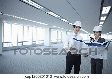 architect executives looking at blueprints in an empty room View Large Photo Image Stock Image - architect executives looking at blueprints in an empty room. Fotosearch