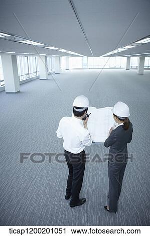 architect executives looking at blueprints together in an empty room View Large Photo Image Stock Image - architect executives looking at blueprints together in an empty room . Fotosearch