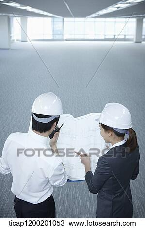 architect executives looking at blueprints together in an empty room View Large Photo Image Stock Image - architect executives looking at blueprints together in an empty room . Fotosearch