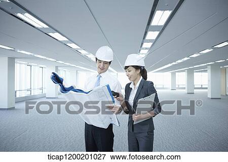 architect executives looking at blueprints in an empty room View Large Photo Image Stock Photo - architect executives looking at blueprints in an empty room. Fotosearch
