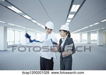 architect executives looking at blueprints in an empty room View Large Photo Image Stock Photo - architect executives looking at blueprints in an empty room. Fotosearch
