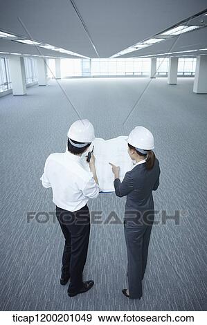 architect executives looking at blueprints together in an empty room View Large Photo Image Stock Photo - architect executives looking at blueprints together in an empty room . Fotosearch