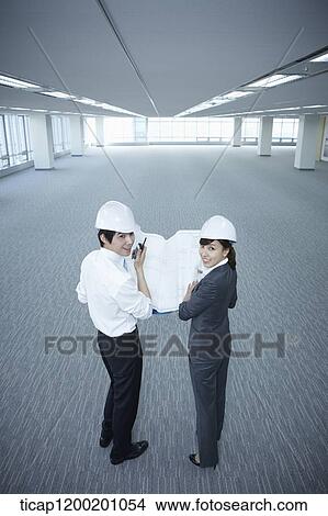 Picture - architect executives looking back in an empty room . Fotosearch