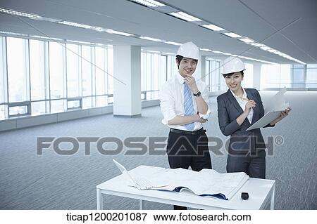 architect executives posing at camera with blueprints on a desk of an empty room View Large Photo Image Stock Photo - architect executives posing at camera with blueprints on a desk of an empty room. Fotosearch