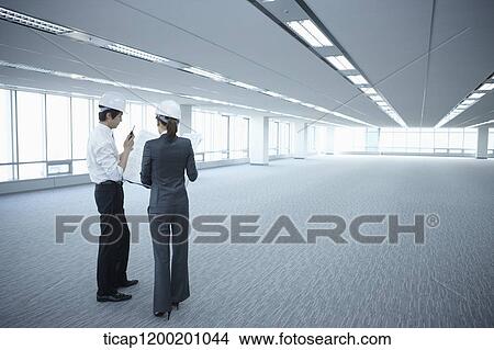 architect executives wearing construction helmets in an empty room View Large Photo Image Picture - architect executives wearing construction helmets in an empty room . Fotosearch