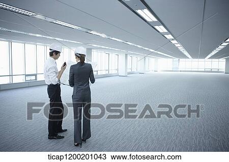 architect executives wearing construction helmets in an empty room View Large Photo Image Stock Image - architect executives wearing construction helmets in an empty room . Fotosearch