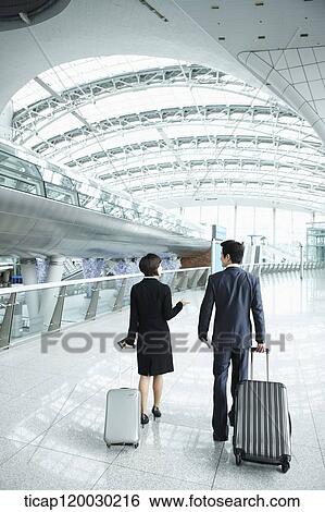back shot of businessman and woman walking in Incheon airport View Large Photo Image Stock Photograph - back shot of businessman and woman walking in Incheon airport. Fotosearch