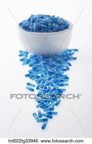 Stock Photograph - blue pills all over a white mortar. Fotosearch