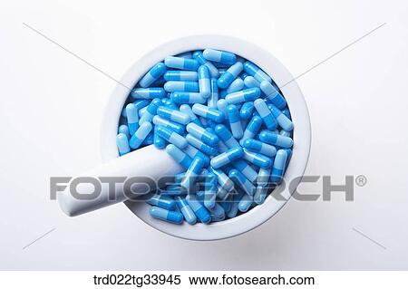 Stock Photography - blue pills filled up in a white mortar. Fotosearch
