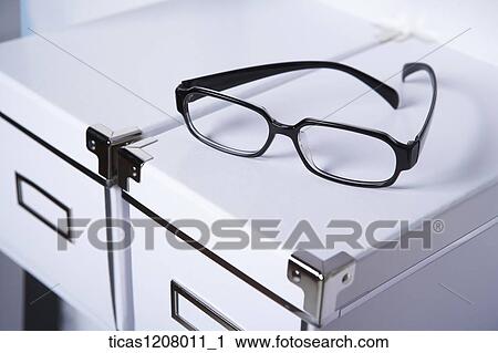 boxes and a pair of glasses on the book shelf View Large Photo Image Stock Image - boxes and a pair of glasses on the book shelf. Fotosearch