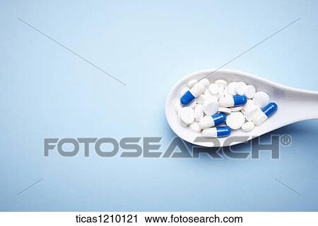 Stock Image - capsules on a Chinese spoon. Fotosearch