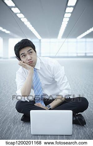 Stock Photo - close up of a businessman thinking while using laptop on the floor . Fotosearch