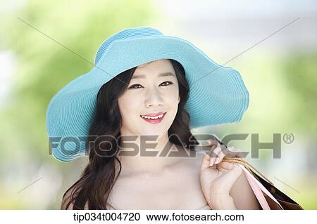 close up shot of a smiling woman in turquoise hat holding shopping bags View Large Photo Image Stock Image - close up shot of a smiling woman in turquoise hat holding shopping bags. Fotosearch