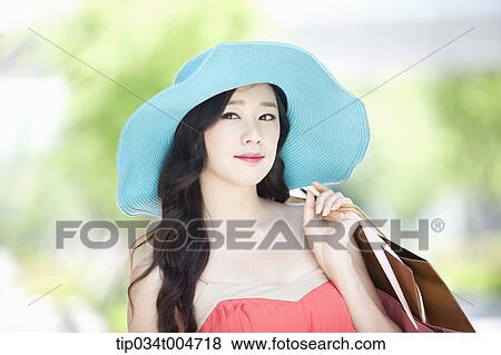 close up shot of a woman in turquoise hat holding shopping bags View Large Photo Image Stock Photo - close up shot of a woman in turquoise hat holding shopping bags. Fotosearch