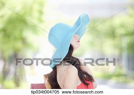 Stock Photography - close up shot of a woman in turquoise hat looking sideways. Fotosearch