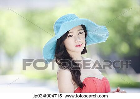 Stock Photography - close up shot of a woman in turquoise hat posing sideways. Fotosearch