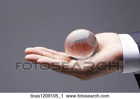 Stock Image - crystal globe in hand . Fotosearch