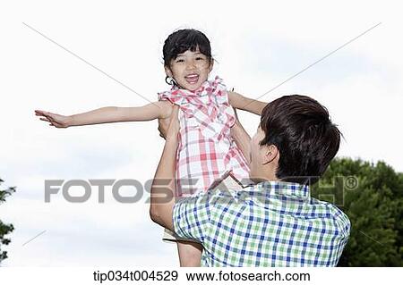 Stock Photo - dad lifting a daughter. Fotosearch