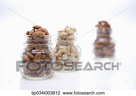 Stock Image - different sorts of nuts in each jar. Fotosearch