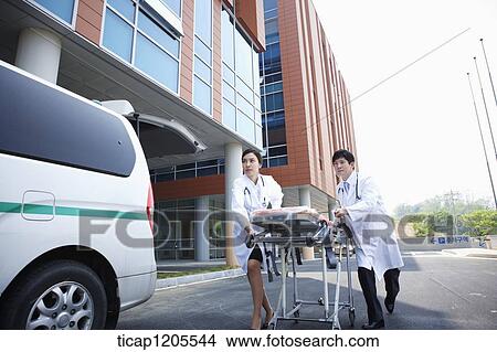 doctors moving a carrier ungently into the hospital View Large Photo Image Picture - doctors moving a carrier ungently into the hospital. Fotosearch