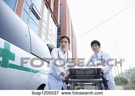 doctors moving a carrier ungently into the hospital View Large Photo Image Stock Photo - doctors moving a carrier ungently into the hospital. Fotosearch
