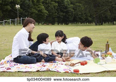 family having a picnic on a picnic blanket View Large Photo Image Stock Photo - family having a picnic on a picnic blanket. Fotosearch